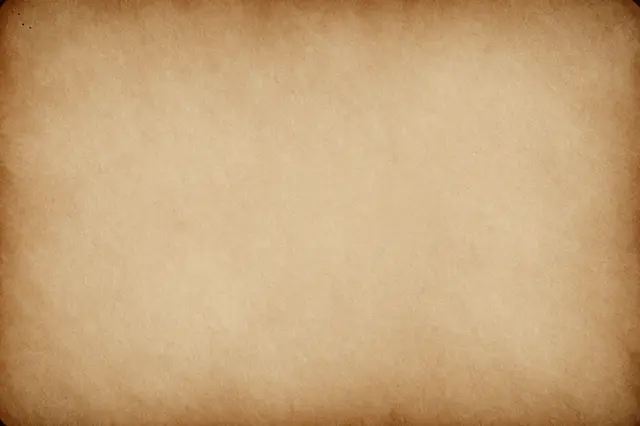 Full frame close-up of worn antique paper with a darker vignette along all edges and a pale warm center