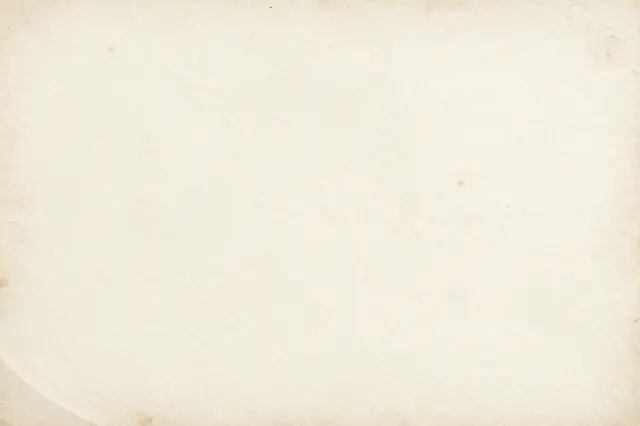 Full frame close-up of a worn, dirty cream grunge paper surface with subtle stains and even lighting
