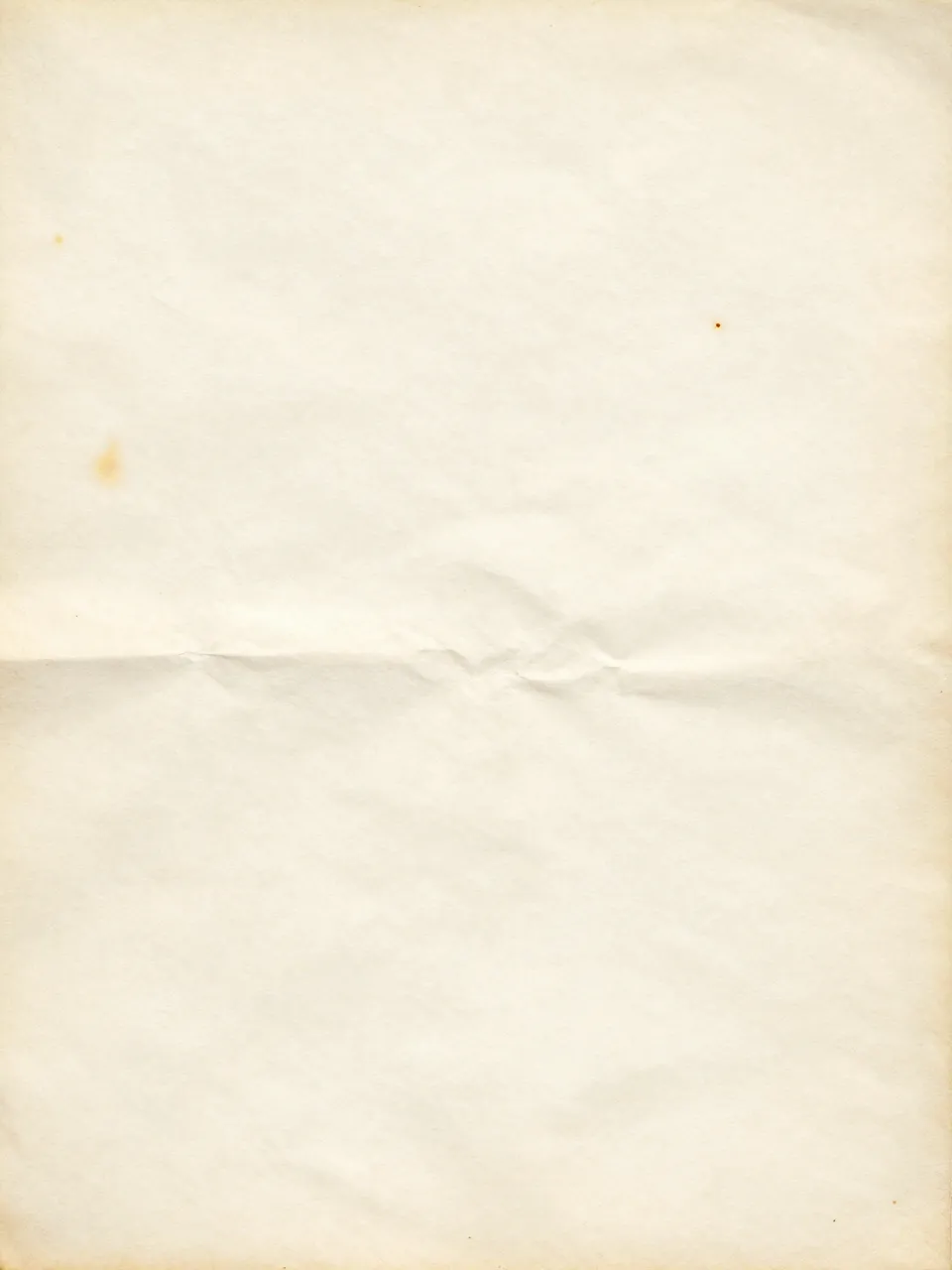 Full frame close-up of aged ivory paper with faint rust spots, soft creases, and even diffused lighting