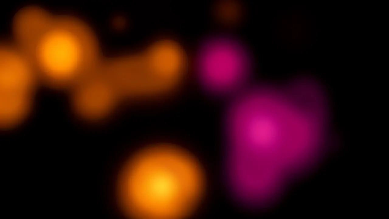 Soft out of focus glowing amber and magenta blurred shapes against a solid black background
