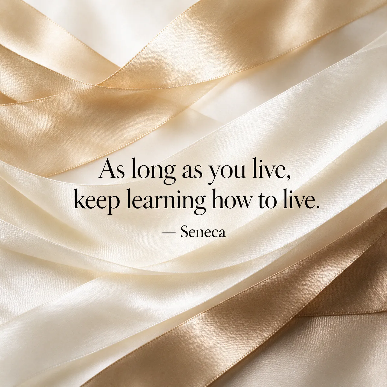 Black serif quote text over flowing champagne and ivory silk ribbons: "As long as you live, keep learning how to live.
