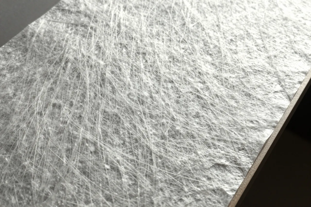 Close-up of backlit translucent washi paper showing its embedded long fibrous texture