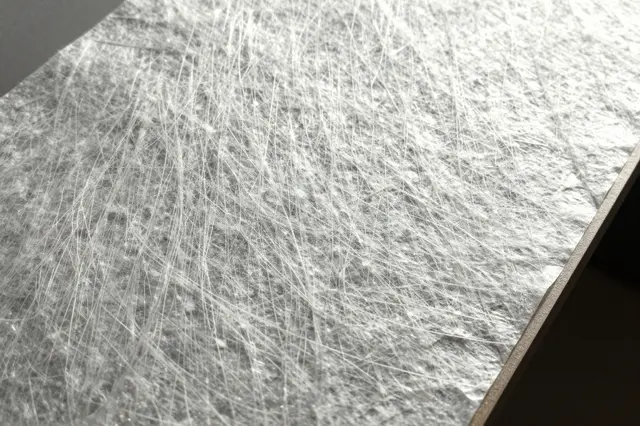 Close-up of backlit translucent washi paper showing its embedded long fibrous texture