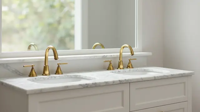 Modern double bathroom vanity with marble countertop and brass faucets beneath a wide window