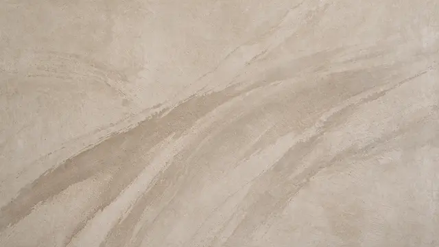 Full frame close-up of satin sealed sand beige microcement with soft sweeping darker tonal arcs