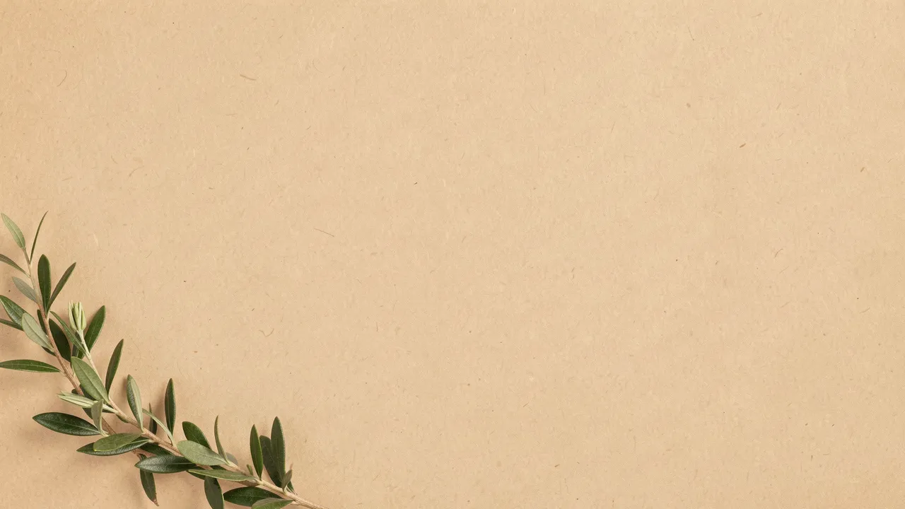 Green botanical sprig rests in the bottom left corner of a warm textured beige paper background with large blank copy space