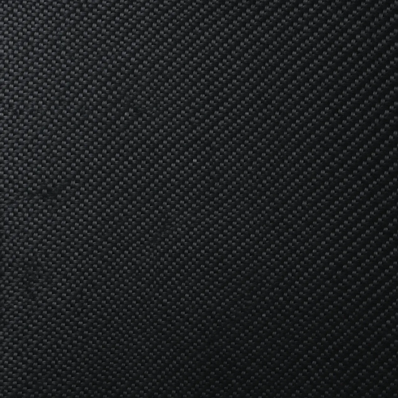 Full frame close-up of a fine diagonal twill weave glossy black carbon fiber surface