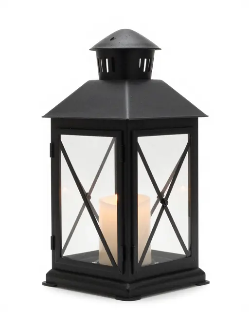 A black metal lantern holding a lit pillar candle sits against a plain white studio background.