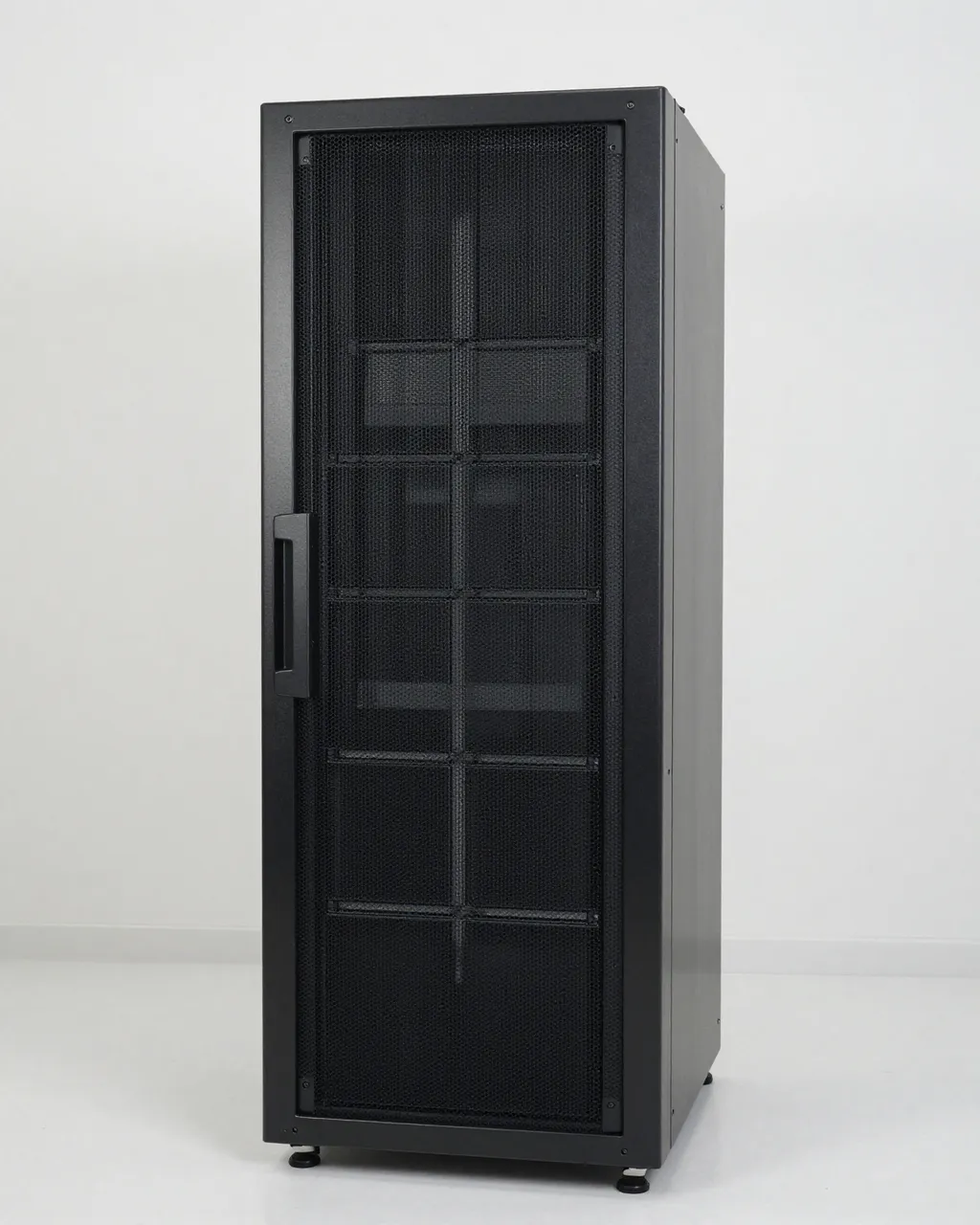 A tall black mesh-front server rack stands in an empty plain white room under even soft light.