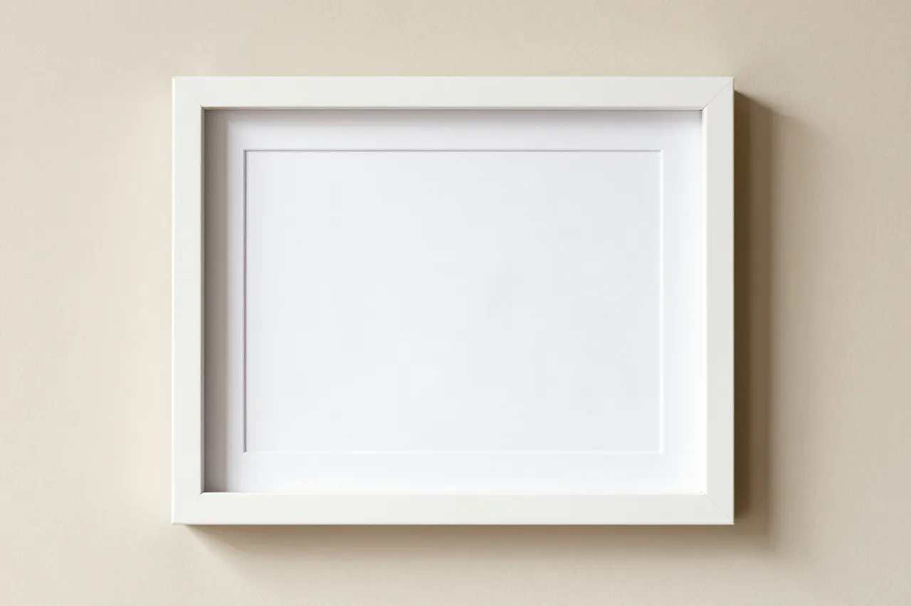 A blank white matted picture frame hangs centered on a smooth beige wall