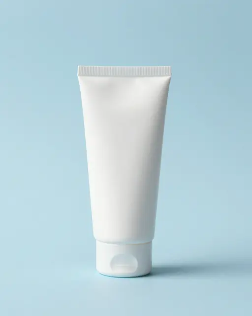 A plain blank white squeeze tube stands upright on a soft pastel blue surface