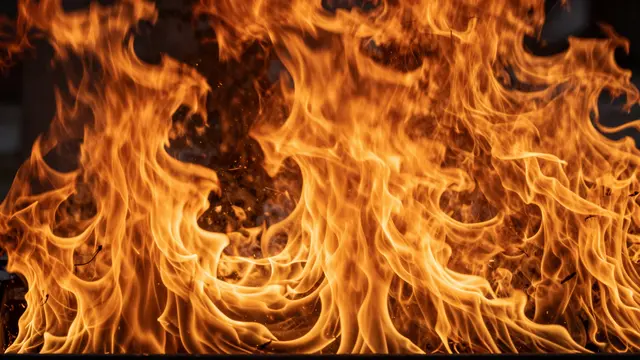 Bright swirling orange and yellow flames fill the entire frame against a dark background