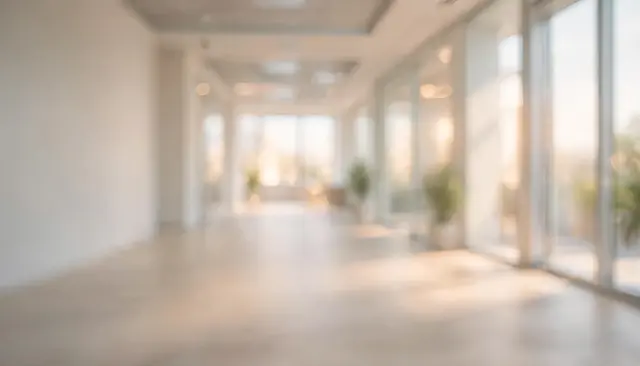 Softly out of focus empty modern office corridor lit by warm daytime sunlight