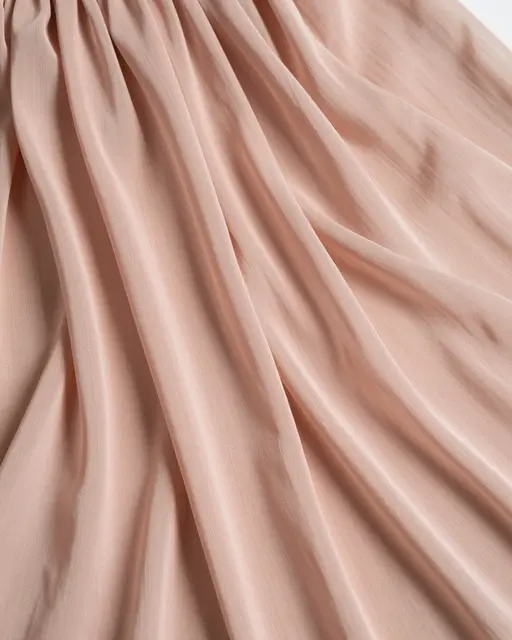 Full frame close-up of gathered soft pleated blush silk chiffon fabric under even lighting