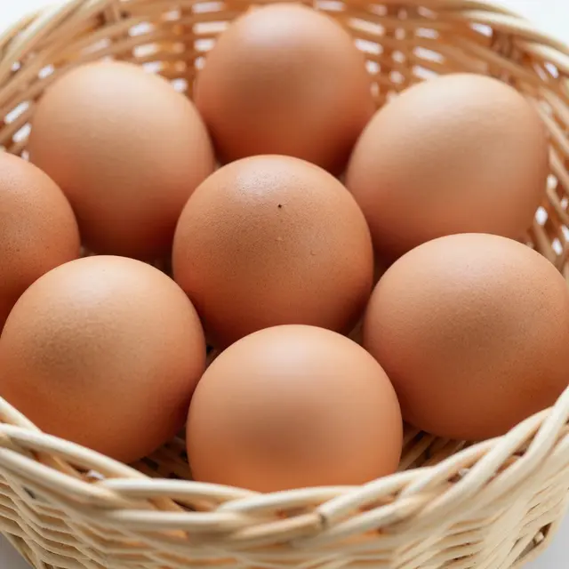 Close-up of whole brown chicken eggs arranged neatly inside a light woven wicker basket.