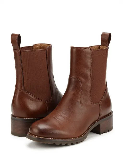 Pair of brown leather elastic-side ankle boots arranged on a plain white studio background