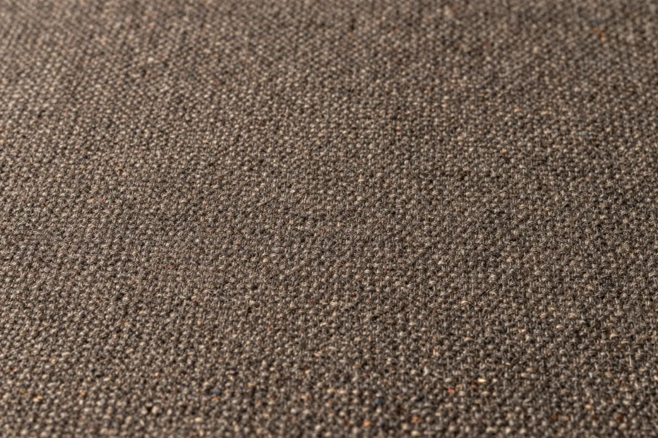 Close-up full frame of woven brown tweed fabric with scattered fine multicolored flecks