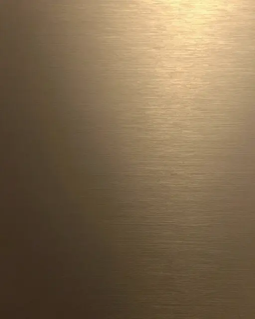 Close-up full frame view of brushed bronze metal with a soft warm upper right gradient reflection