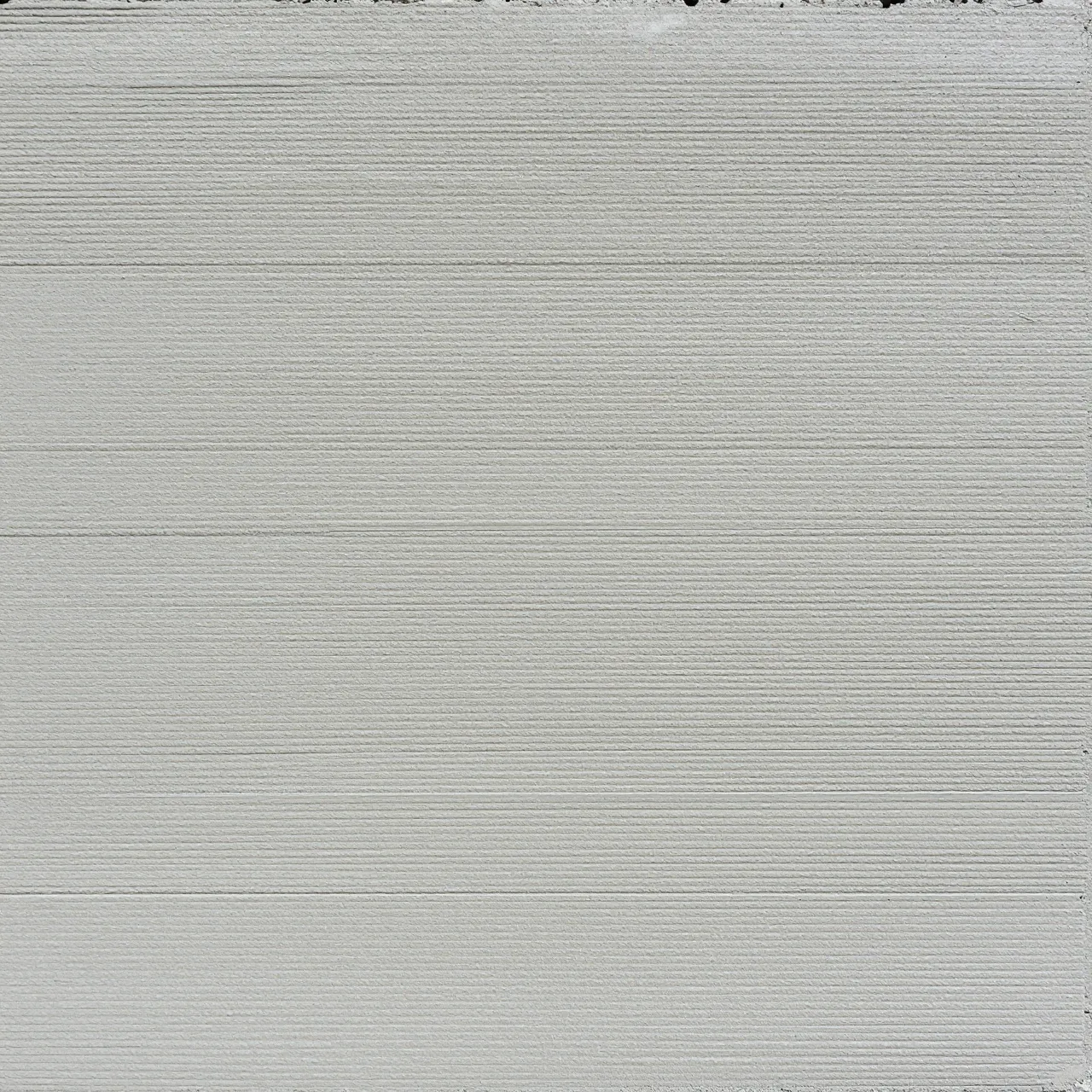 Full frame top view of light gray brushed concrete with fine parallel horizontal grooves