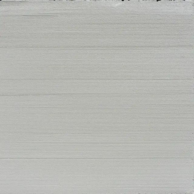 Full frame top view of light gray brushed concrete with fine parallel horizontal grooves