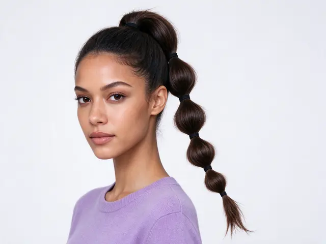 Mixed-race woman in a lavender top with a bubble ponytail looks toward the camera in a bright studio