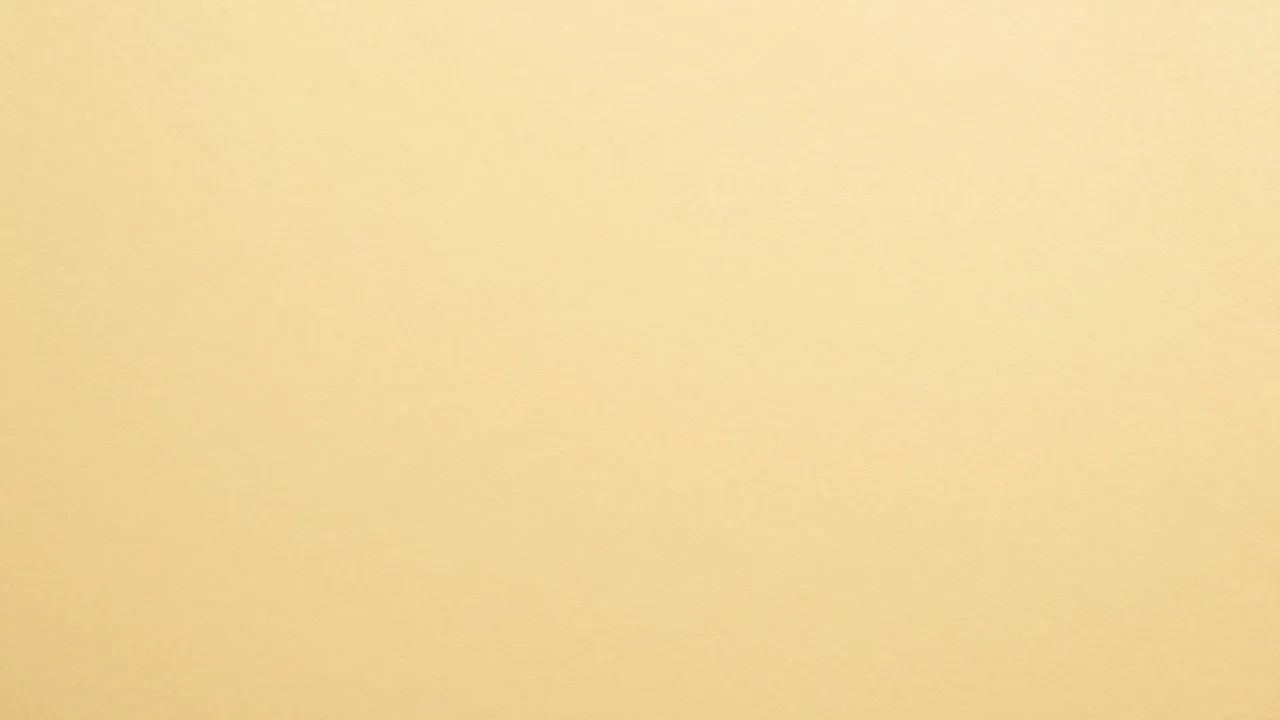 Full frame close-up of a smooth matte buff yellow manila paper surface