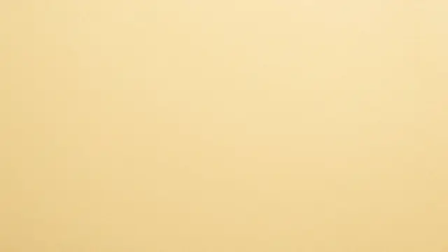 Full frame close-up of a smooth matte buff yellow manila paper surface