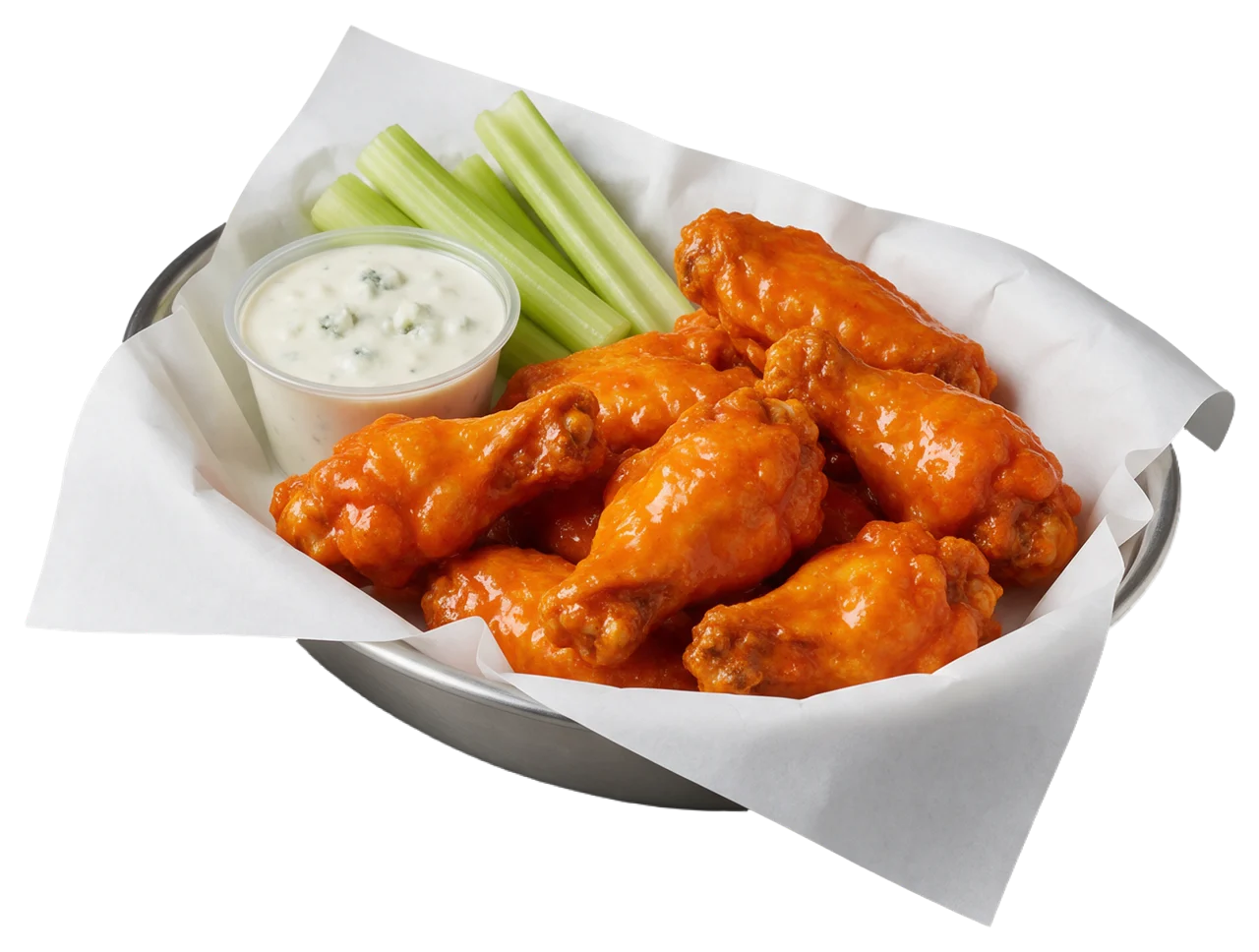 Metal basket lined with paper holds glossy buffalo wings, celery sticks, and blue cheese dip.