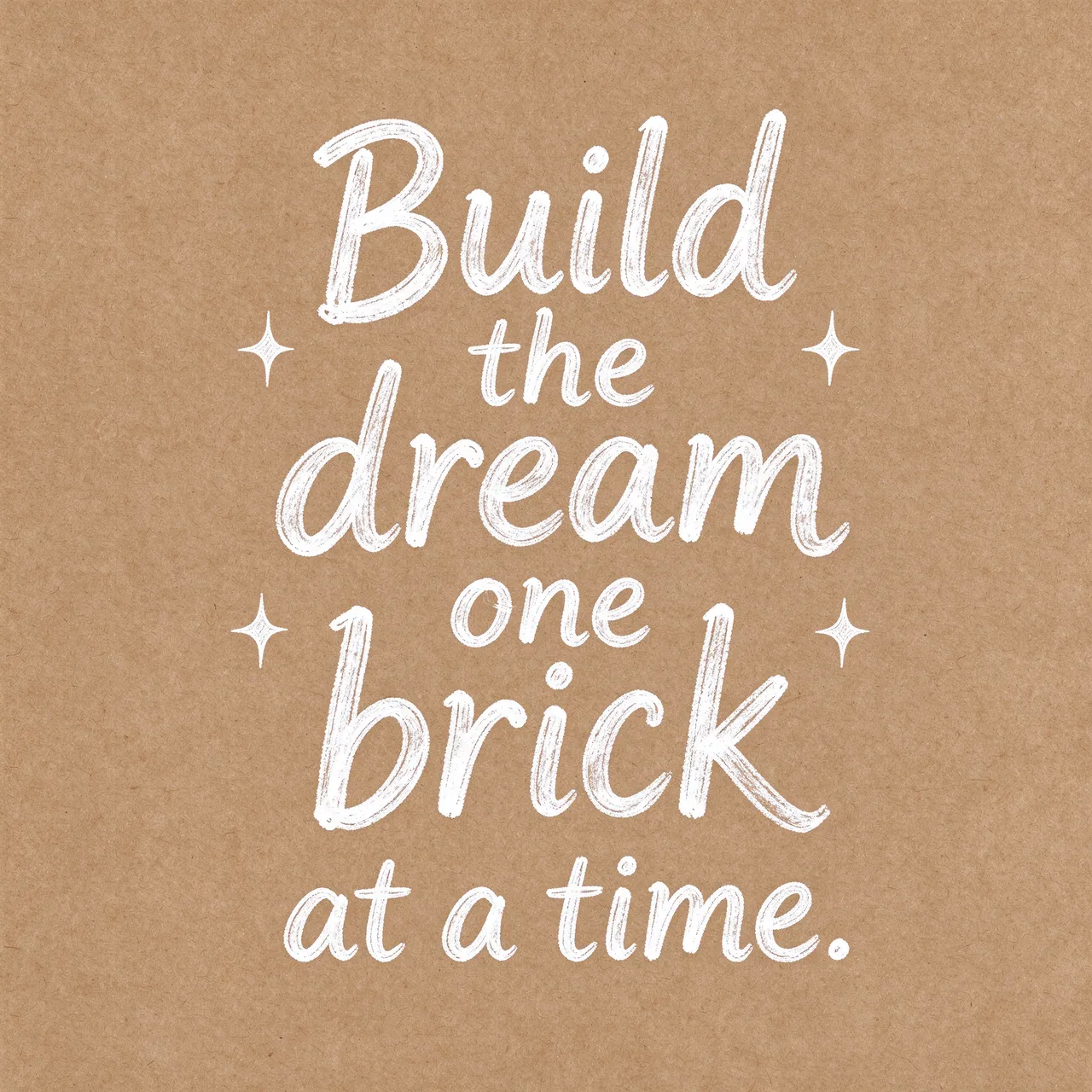 White hand lettering reading "Build the dream one brick at a time." with small star doodles on brown kraft paper.