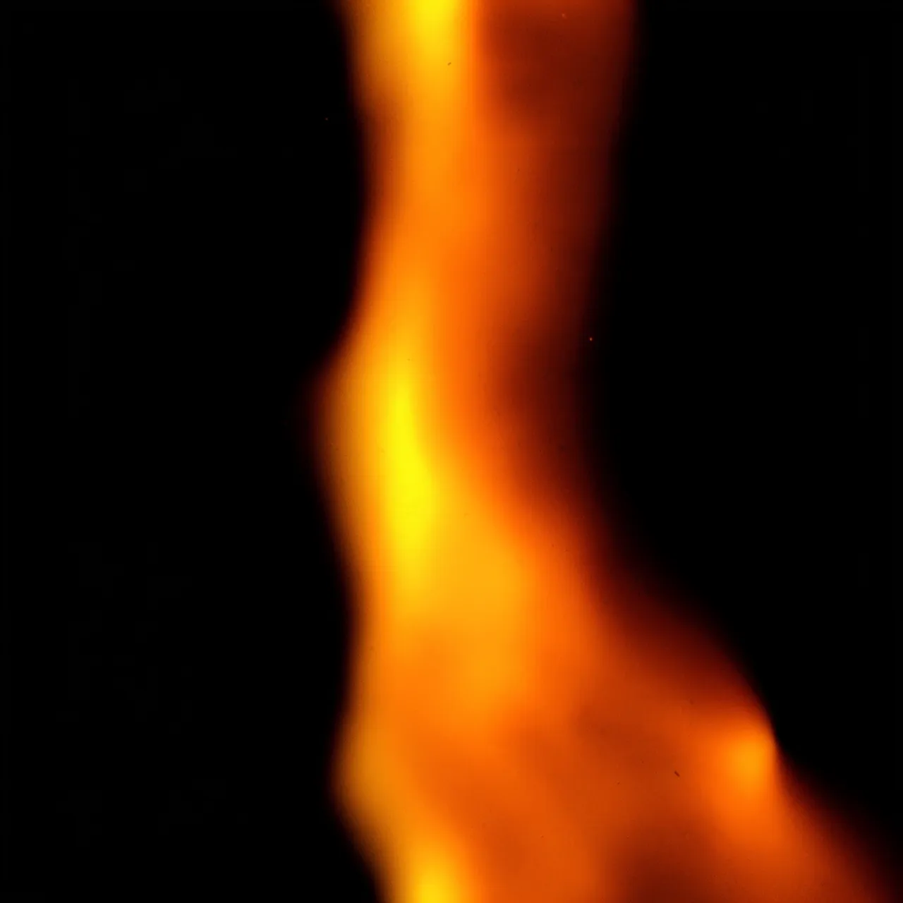 A soft burnt orange light leak with bright yellow highlights sits on a pure black background
