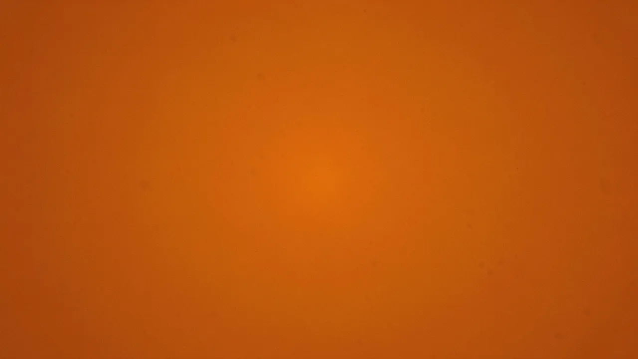 A full frame burnt orange background with soft grain and a subtle central warm glow