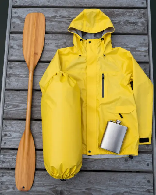 Canoe trip gear laid flat on weathered wooden dock planks