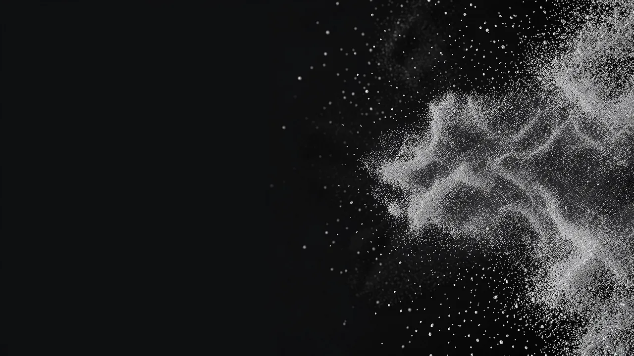 Fine silver dust drifts from the right edge of a dark charcoal background with empty copy space on the left