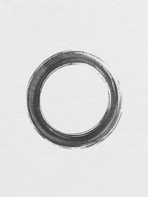 A textured brushed charcoal enso circle centered on light textured rice paper