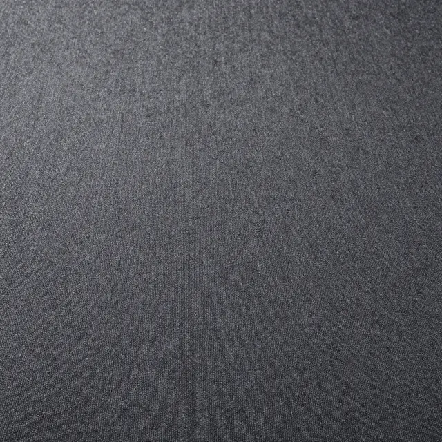 Close-up top view of fine textured low-pile charcoal carpet under flat even lighting