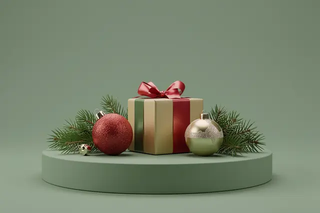 Festive Christmas gift, baubles and pine sprigs arranged on a round sage green display podium with empty background space.