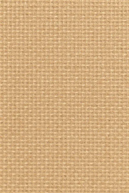 Full frame close-up of a natural tan woven jute fiber surface with flat even lighting