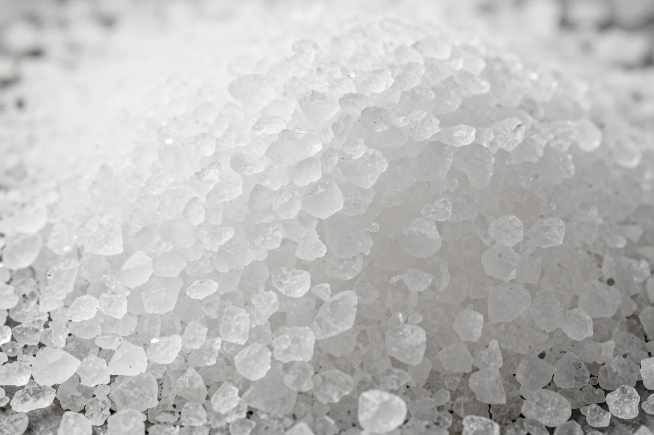 Close-up macro view of a pile of translucent white coarse sea salt crystals