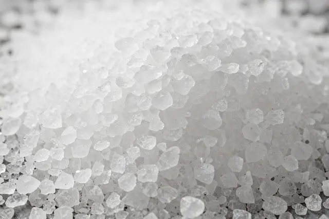 Close-up macro view of a pile of translucent white coarse sea salt crystals