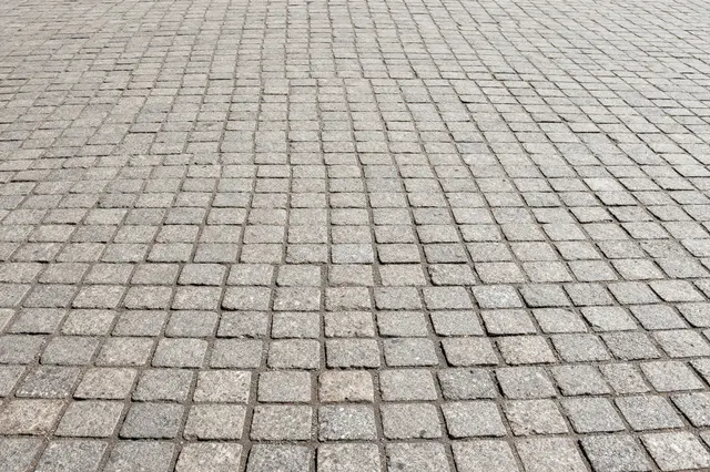 Diagonal perspective view of uniform light gray cobblestone pavement extending across the frame