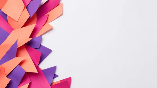 Coral, pink and purple geometric paper shapes cluster along the left edge with empty white copy space on the right