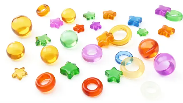 Assorted translucent candy-colored gummy spheres, rings and stars scattered across a plain white background