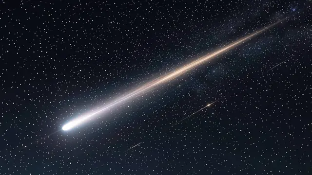 A bright glowing comet with a long trailing streak moves diagonally across a dark star-filled night sky