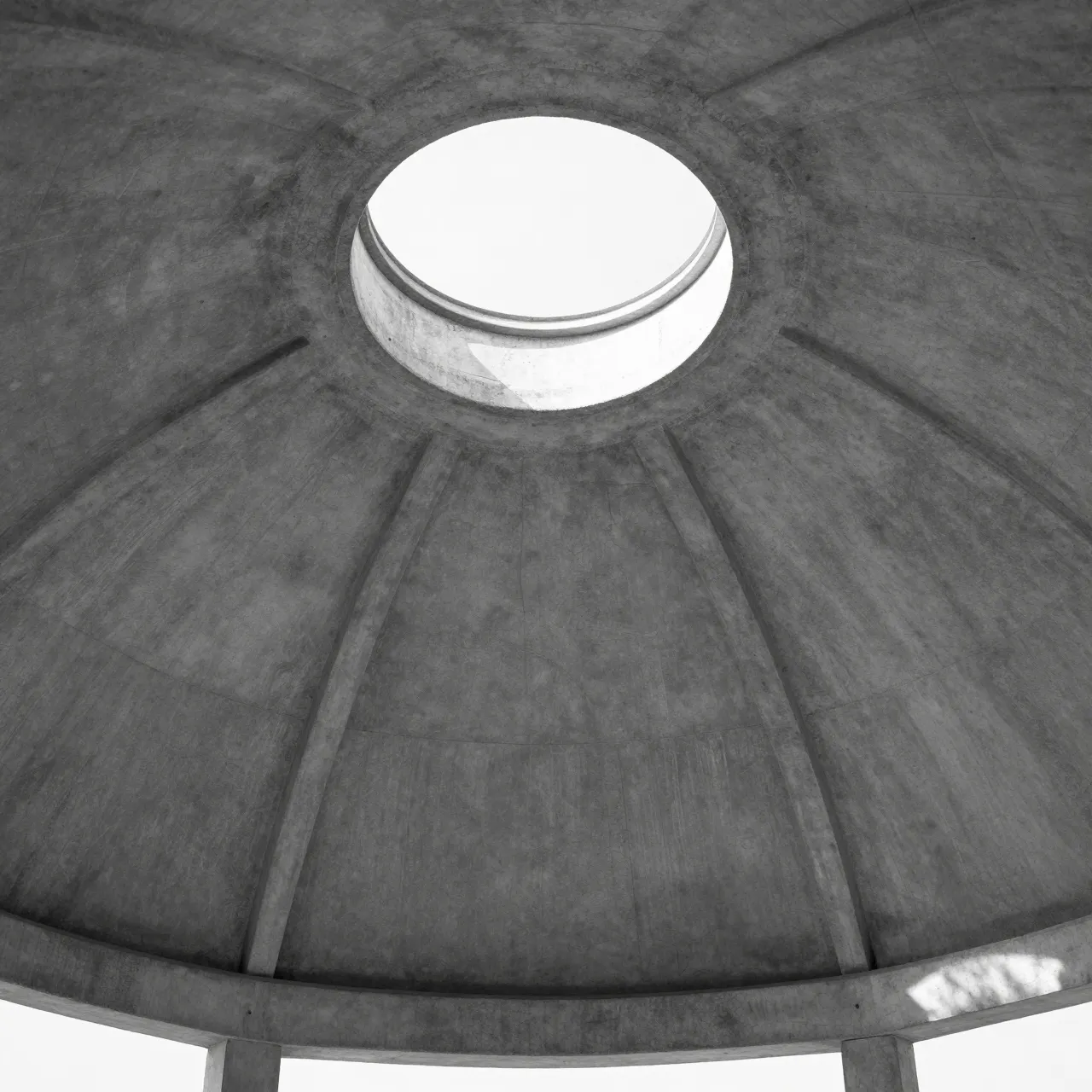 Low angle black and white view looking up at a textured concrete pavilion dome with a central round skylight
