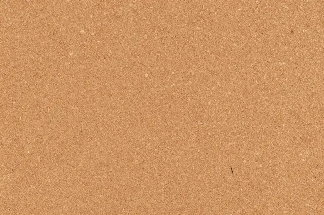 Seamless warm tan textured cork board surface filling the entire frame