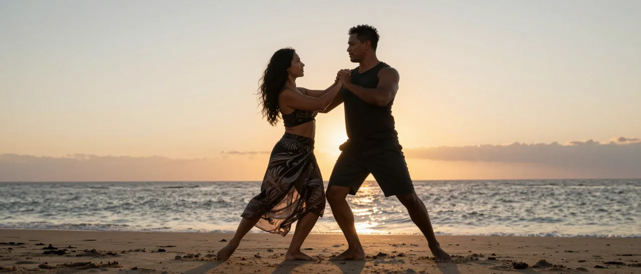 A couple dances barefoot together on a sandy ocean beach during golden sunset