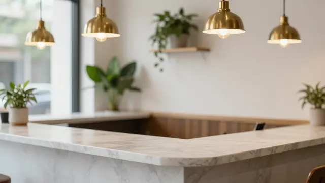 Softly blurred empty coffee shop interior with marble counter, brass pendants and potted plants