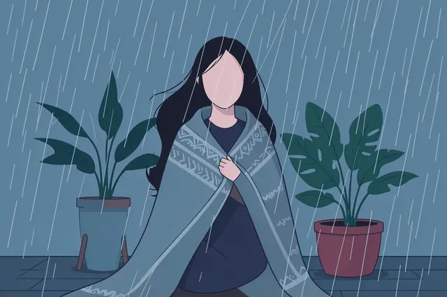 Faceless woman wrapped in a patterned blanket sits between potted houseplants during rain