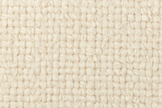 Full frame close-up of soft cream looped boucle fabric surface showing its textured yarn structure