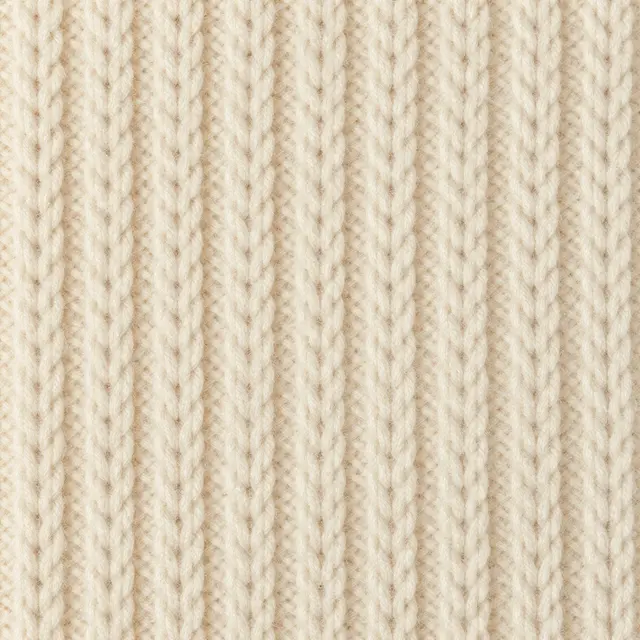 Full frame close-up of even ribbed chunky cream wool knit fabric under flat soft light